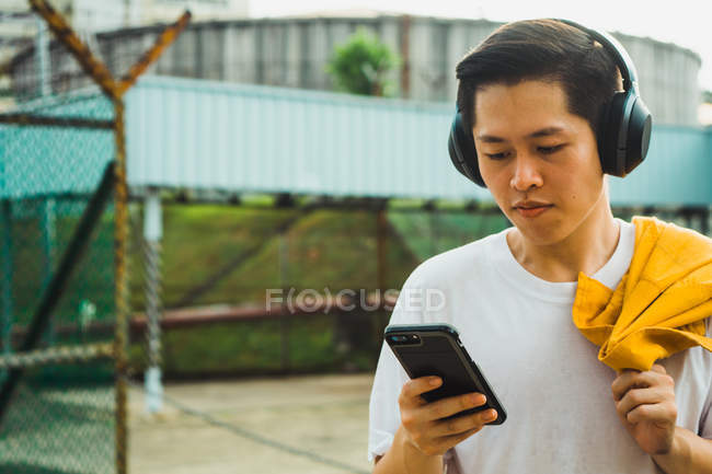 Joven asiático elegante hombre usando smartphone - foto de stock