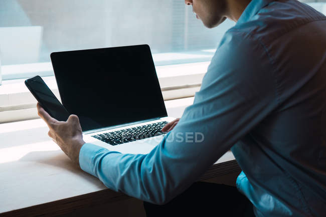 Joven asiático exitoso hombre de negocios usando laptop en oficina - foto de stock