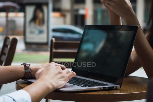 Abgeschnittenes Bild eines jungen asiatischen Geschäftspaares, das am Laptop arbeitet — Stockfoto