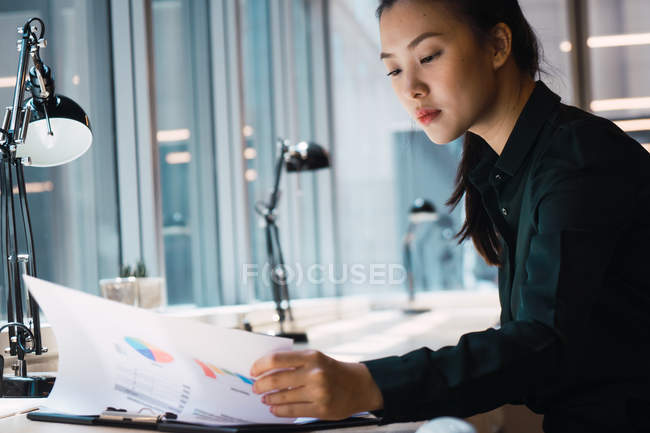 Junge erfolgreiche asiatische Geschäftsfrau arbeitet im modernen Büro — Stockfoto