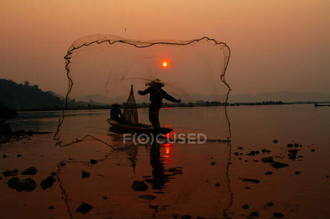 Fischer wirft sein Netz aus — Stockfoto