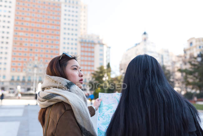 Asian women doing tourism in Madrid with map, Spain — Stock Photo