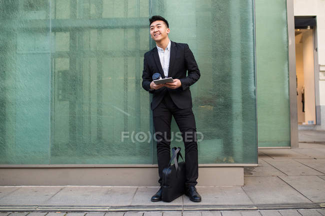 Hombre de negocios chino con una tableta en la calle - foto de stock