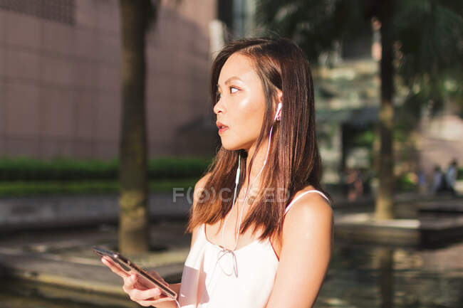 Bella asiatico ragazza con telefono in il strada — Foto stock