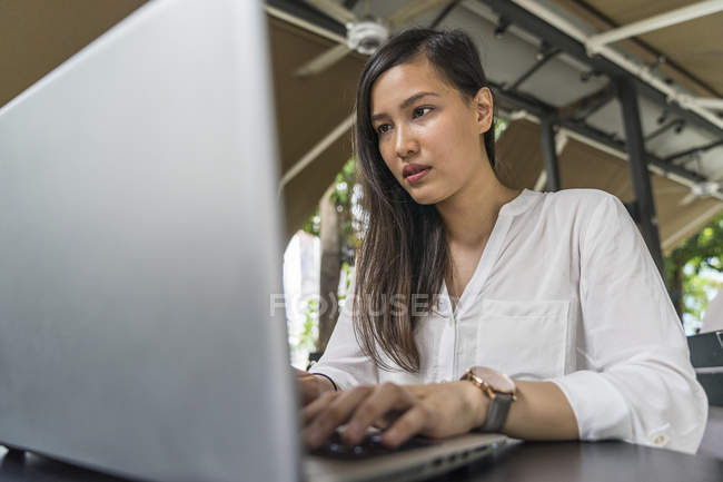 Jovem bela mulher asiática usando laptop — Fotografia de Stock