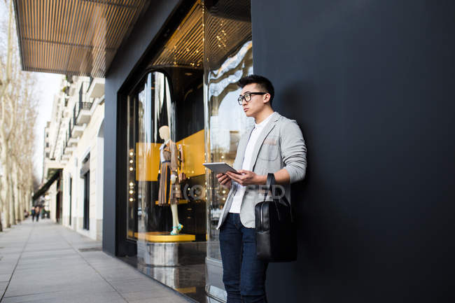 Homme d'affaires chinois debout à côté d'un magasin de luxe à Serrano Street, Madrid, Espagne — Photo de stock