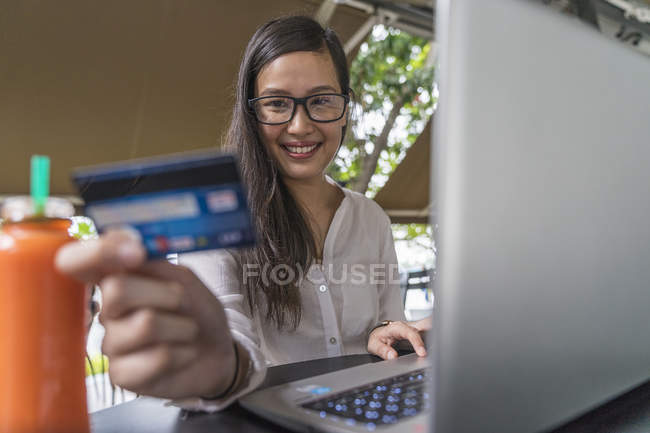 Jovem bela mulher asiática fazendo transação com laptop — Fotografia de Stock