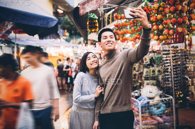 Feliz casal asiático celebrando Ano Novo Chinês na cidade e tomando selfie — Fotografia de Stock