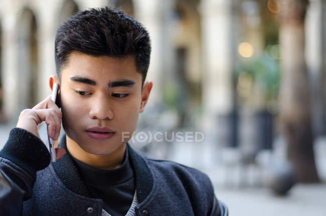 Портрет молодого азиата на мобильном телефоне в Барселоне, Испания — стоковое фото