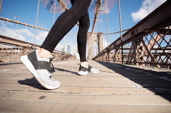 Muito asiático corredor menina formação ao ar livre trabalhando fora no Brooklyn ponte com Manhattan, Nova York no fundo . — Fotografia de Stock