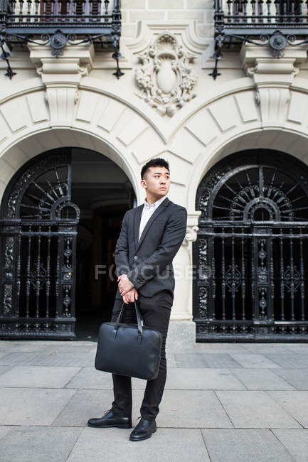 Uomo d'affari cinese intelligente in piedi per strada a Madrid, Spagna — Foto stock