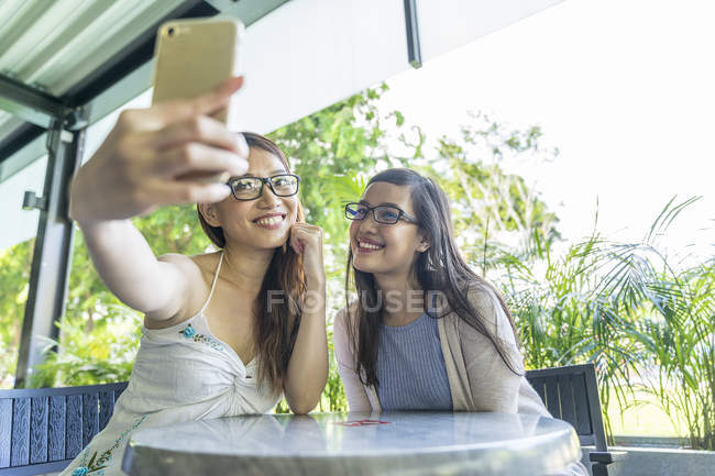 Jeune attrayant asiatique femmes prendre selfie dans café — Photo de stock