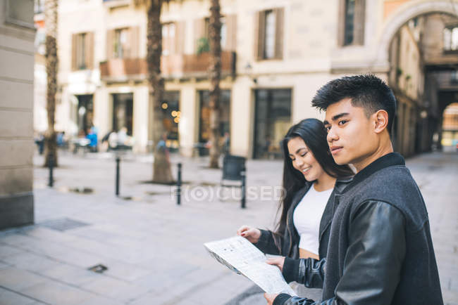 Молодая пара смотрит на карту Барселоны, Испания — стоковое фото