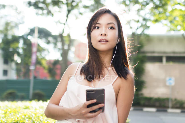 Menina asiática bonita com telefone na rua — Fotografia de Stock