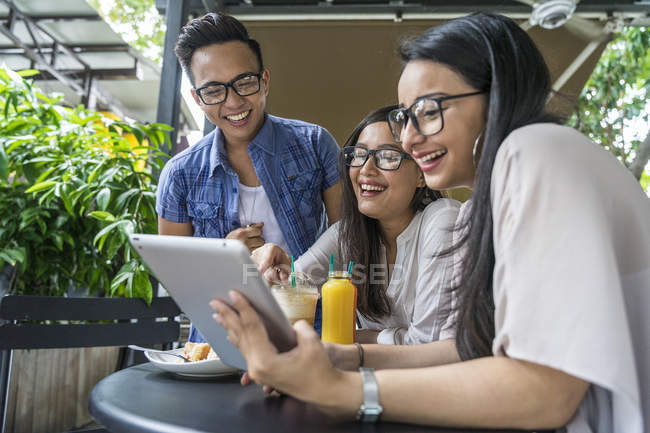 A Group Of Friends Sharing Something Interesting On Their Gadgets. — Stock Photo