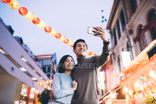 Glückliches asiatisches Paar feiert chinesisches Neujahr in der Stadt und macht Selfie — Stockfoto