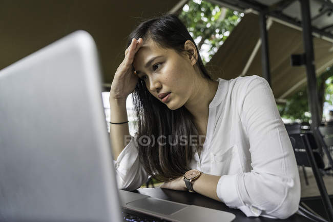 Junge schöne asiatische Frau arbeitet mit Laptop — Stockfoto