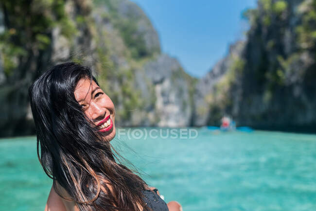 Woman sitting on a boat, filled with laughter and happiness as she takes in the beautiful nature — Stock Photo