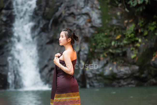 Attrayant asiatique jeune femme relaxant près de cascade en Thaïlande — Photo de stock