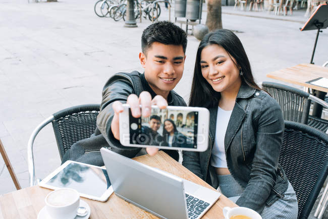 Счастливая молодая азиатская туристическая пара делает селфи на смартфоне в Барселоне, Испания — стоковое фото