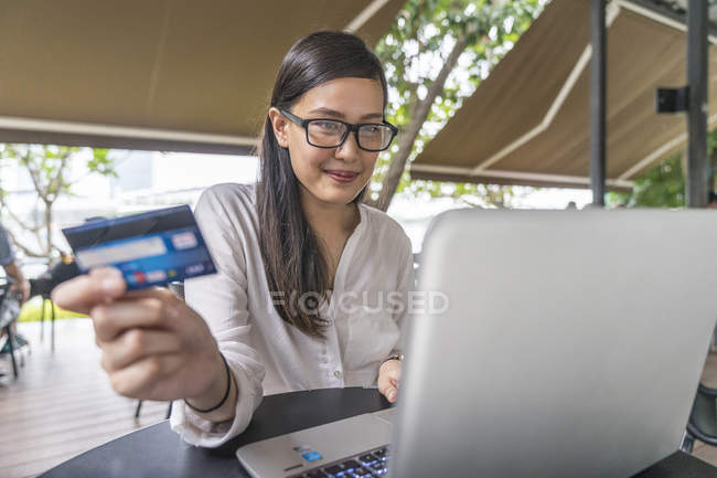 Jovem bela mulher asiática fazendo transação com laptop — Fotografia de Stock