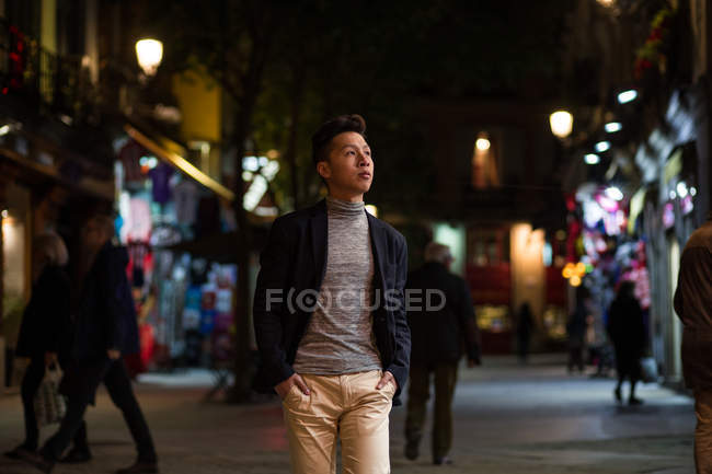 Casual young chinese man hanging around in the streets of Madrid at night, Spain — Stock Photo