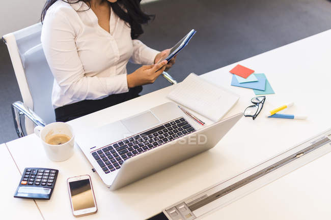 Женщина, работающая со своим планшетом в современном офисе — стоковое фото