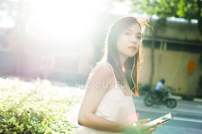 Menina asiática bonita com telefone na rua — Fotografia de Stock