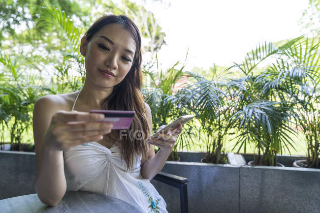 Китайська жінка, що час здійснення транзакцій з її дебетова картка. — стокове фото