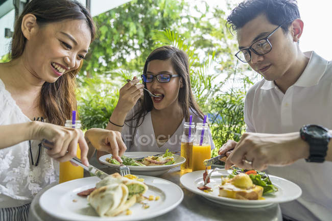 Un grupo de amigos están disfrutando de su comida . - foto de stock