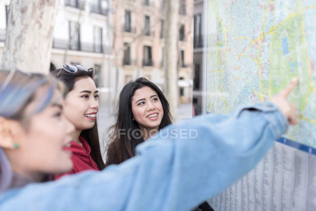 Три жінки в Іспанії, дивлячись на дошці карту — стокове фото