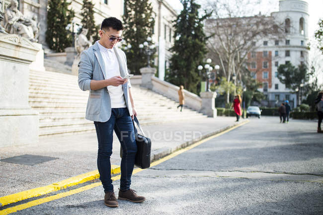 Homem de negócios chinês mensagens de texto no telefone na rua em Madrid, Espanha — Fotografia de Stock