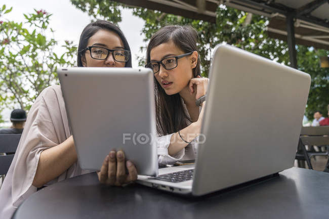 Young beautiful asian women using digital devices — Stock Photo