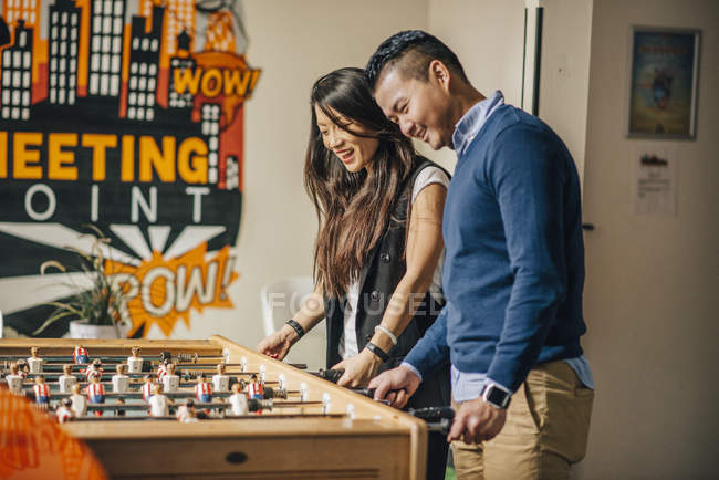 Chinesisches Paar spielt Tischfußball in einem Hostel in Madrid, Spanien — Stockfoto