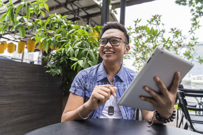 Ein philippinischer mann spielt mit seinem tablet im cafe — Stockfoto