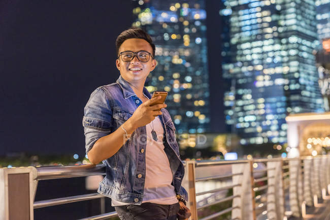 Молода людина, граючи з його смартфон в місті — стокове фото