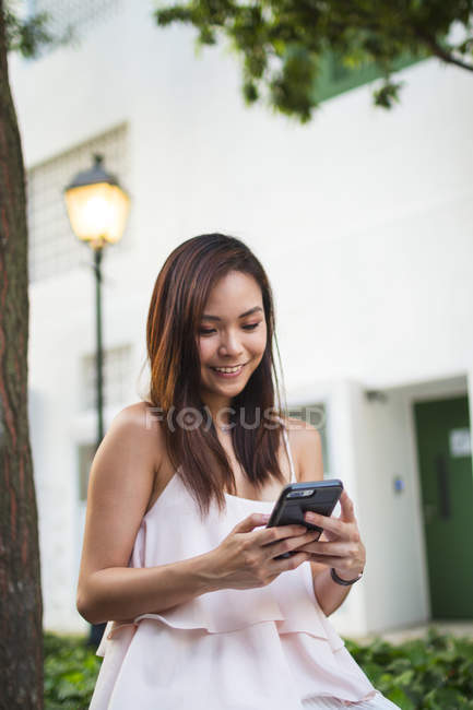 Schön asiatische Mädchen mit Telefon in die Straße — Stockfoto