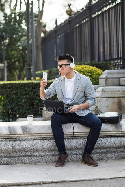 Empresário chinês trabalhando ao ar livre usando um laptop, Espanha — Fotografia de Stock