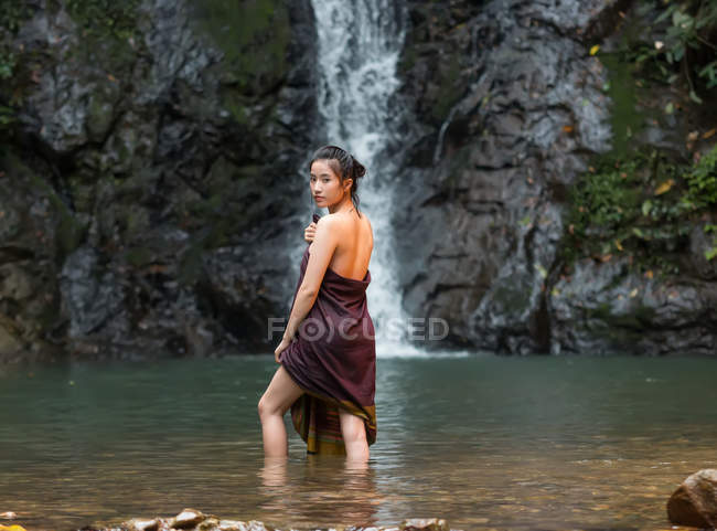 Atractivo asiático joven mujer relajante cerca de cascada en Tailandia - foto de stock