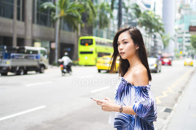 Jolie asiatique fille dans l 'rue avec smartphone — Photo de stock