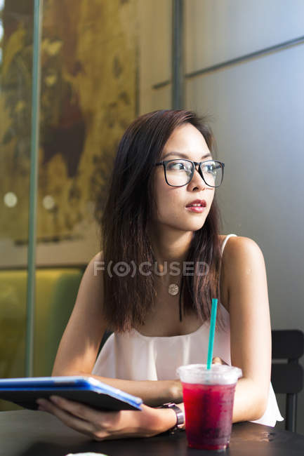 Jolie asiatique fille dans lunettes avec tablette — Photo de stock