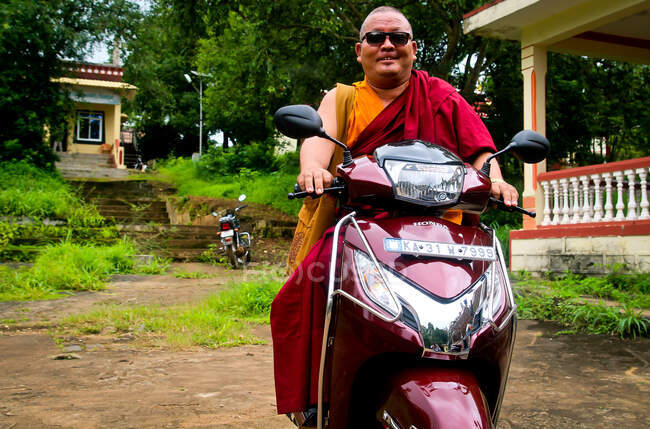 Un monaco posa nella sua moto. — Foto stock