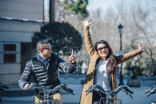 Chinese couple in Madrid riding a bike — Stock Photo