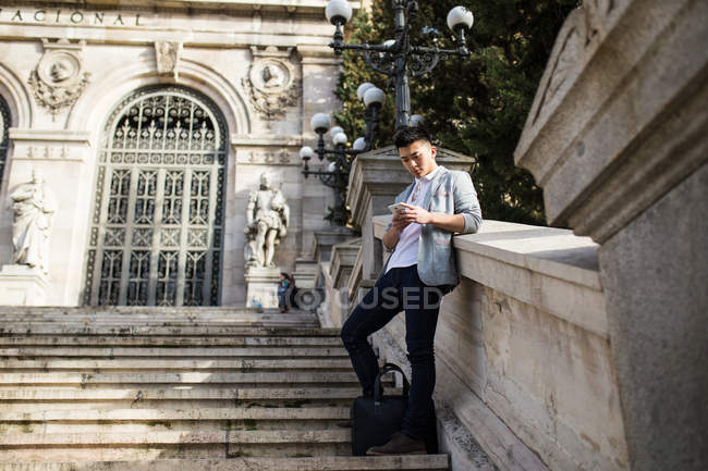 Китайський бізнесмен текстові повідомлення на телефон на вулиці в Мадриді, Іспанія — стокове фото