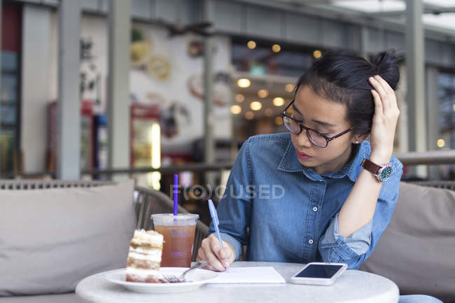Молода жінка Дрочить деяку інформацію в кафе . — стокове фото