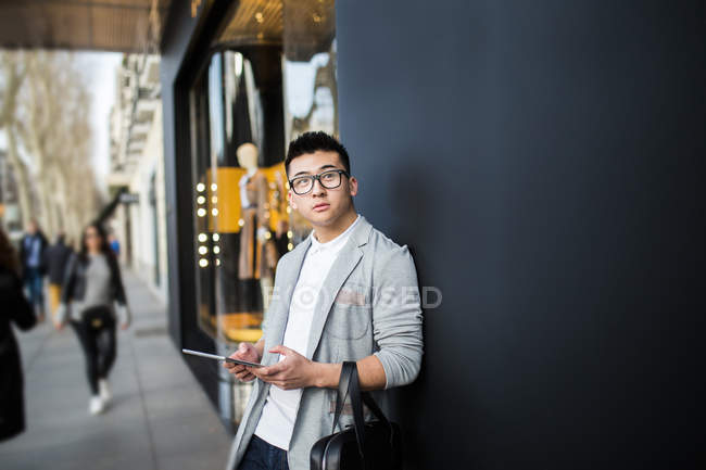 Homme d'affaires chinois debout à côté d'un magasin de luxe à Serrano Street, Madrid, Espagne — Photo de stock
