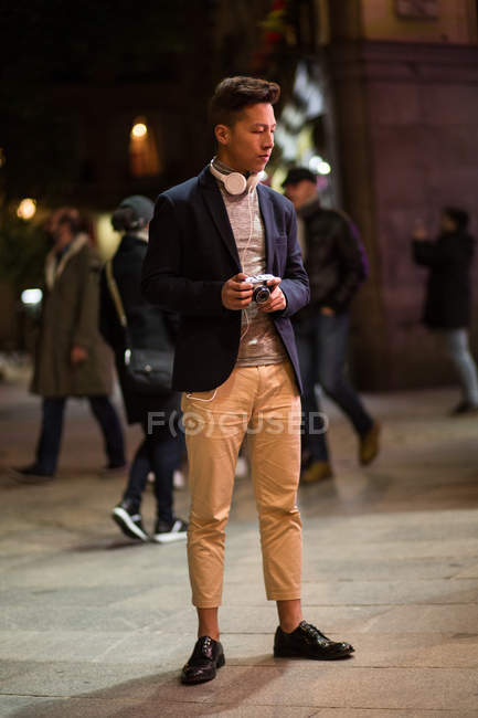 Casual jovem chinês pendurado nas ruas de Madrid à noite com câmera, Espanha — Fotografia de Stock