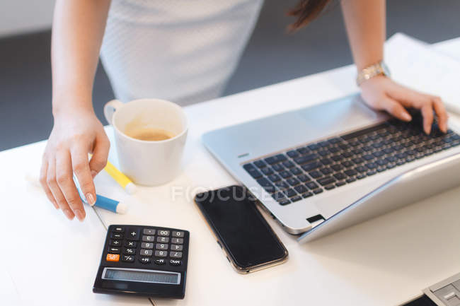 Mulher ocupada trabalhando em seu laptop no escritório moderno — Fotografia de Stock