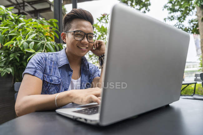 Un uomo filippino che fa il lavoro sul suo computer portatile nel caffè — Foto stock