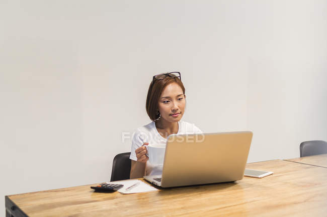 Jeune femme travaillant dans l'environnement de démarrage dans le bureau moderne — Photo de stock